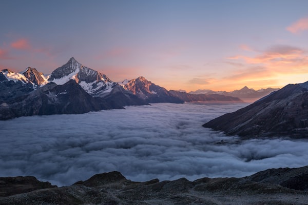 Bergsee mit Spiegelung der umliegenden Gipfel im Morgenlicht